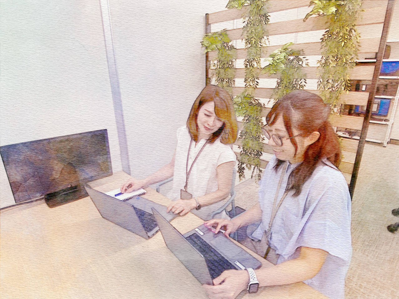 社内で社員同士がPCを使って業務の相談をしている様子。TOMEYの相談しやすく協力的な職場環境が伝わる場面。